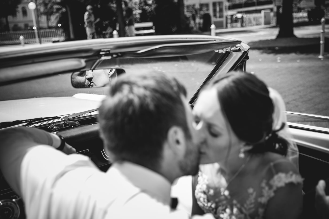 Brautpaar im Oldtimer mit Blick durch den Rückspiegel – Hochzeitsfotograf | Hochzeitsvideograf NRW