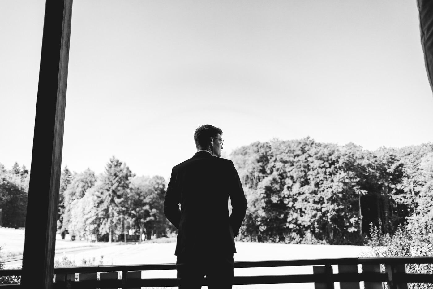 Bräutigam in Schwarz-Weiß-Aufnahme blickt in die Ferne – Hochzeitsfotograf Detmold